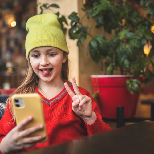 The child takes a selfie. Child and gadgets. Smartphone use. Young blogger. Blogging. Child blogger.